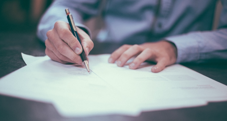 An Insurance Agent Signing An Sr22 Document.