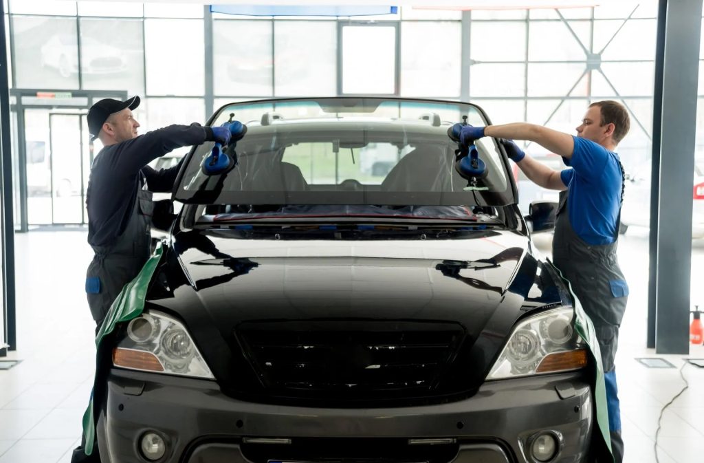 men replacing a car windshield