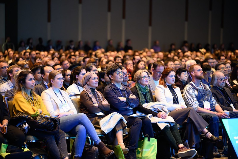 A group of people listen to a keynote speech in the banquet hall