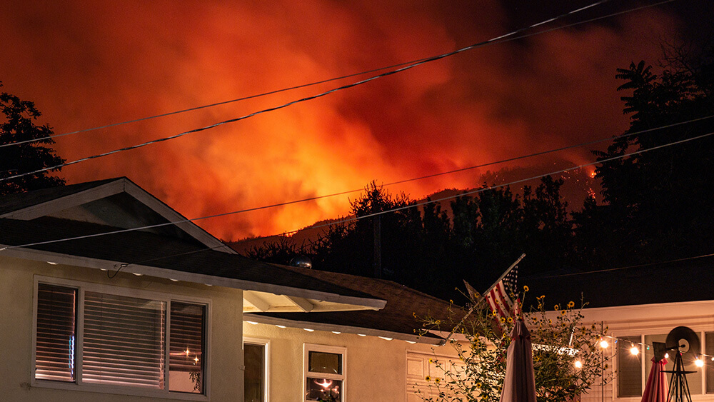 fire raging above houses