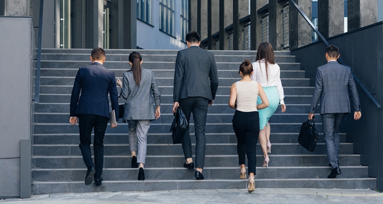 corporate dressed group walking up stairs to office