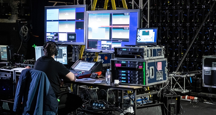 man using AV equipment backstage