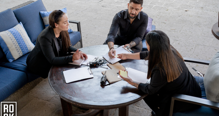 Event Planning Meeting With Two Women And One Man Seated At A Round Table