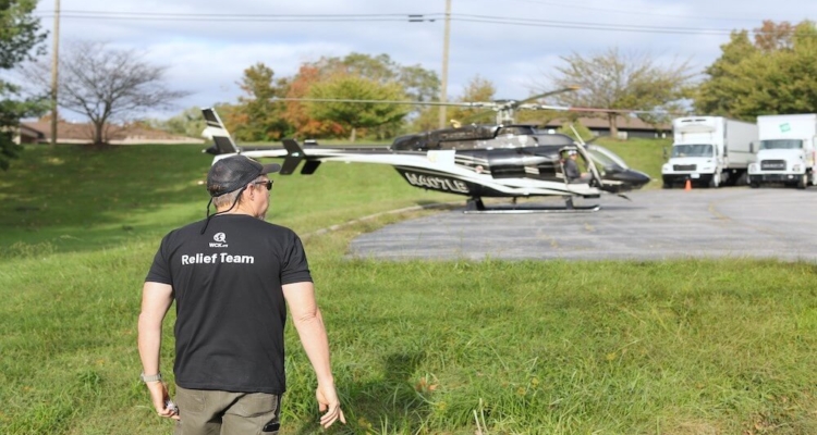 A Volunteer Worker Walks Toward A Helicopter.