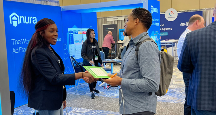 Two People Shaking Hands At Expo Booth