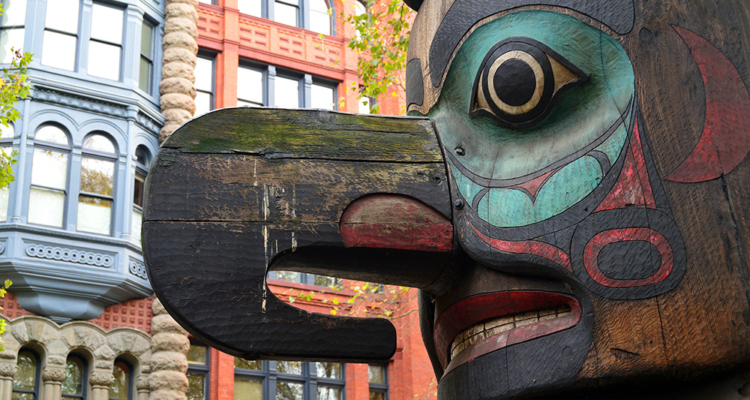 blue and red painted face and large nose of totem