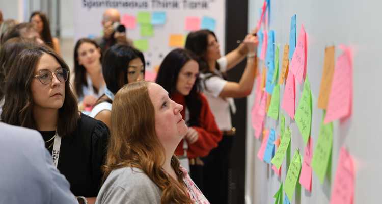 Women Posting Sticky Notes On Wall