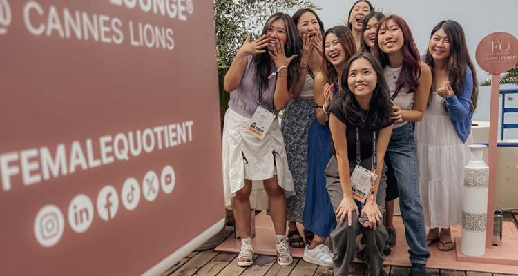 Women Pose Near Female Quotient Sign