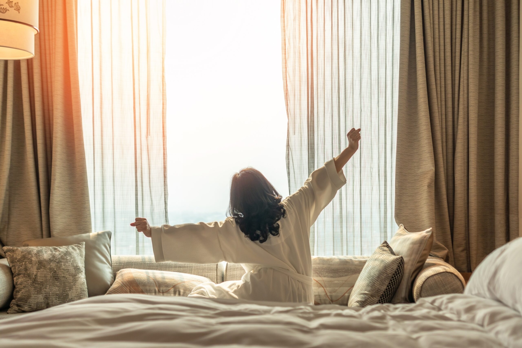 Woman waking up from a good nights sleep on bed