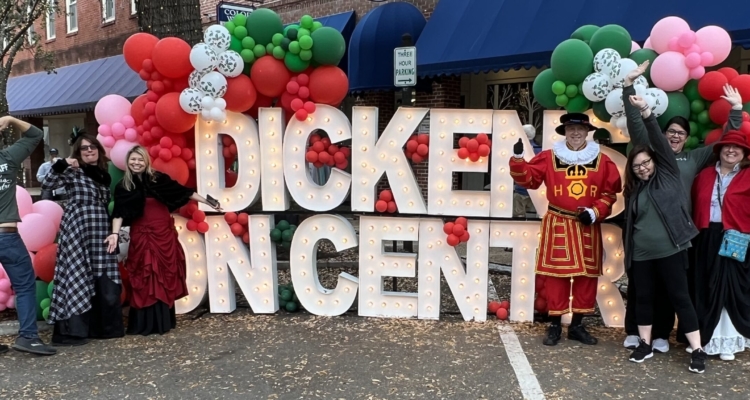 group posing in front of Dickens on Centre sign