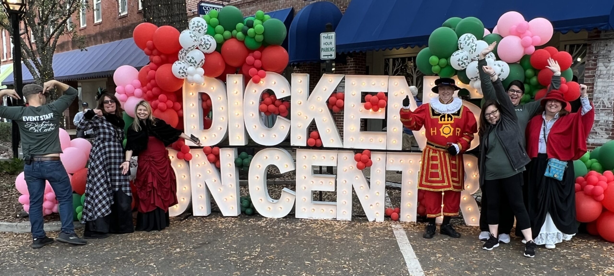 group posing in front of Dickens on Centre sign