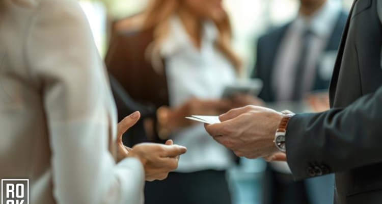 image of a man handing out a business card at an event to capture a potential lead