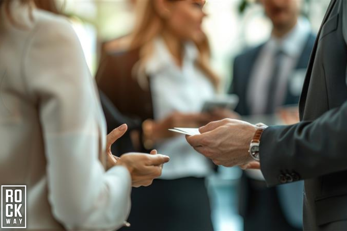 image of a man handing out a business card at an event to capture a potential lead