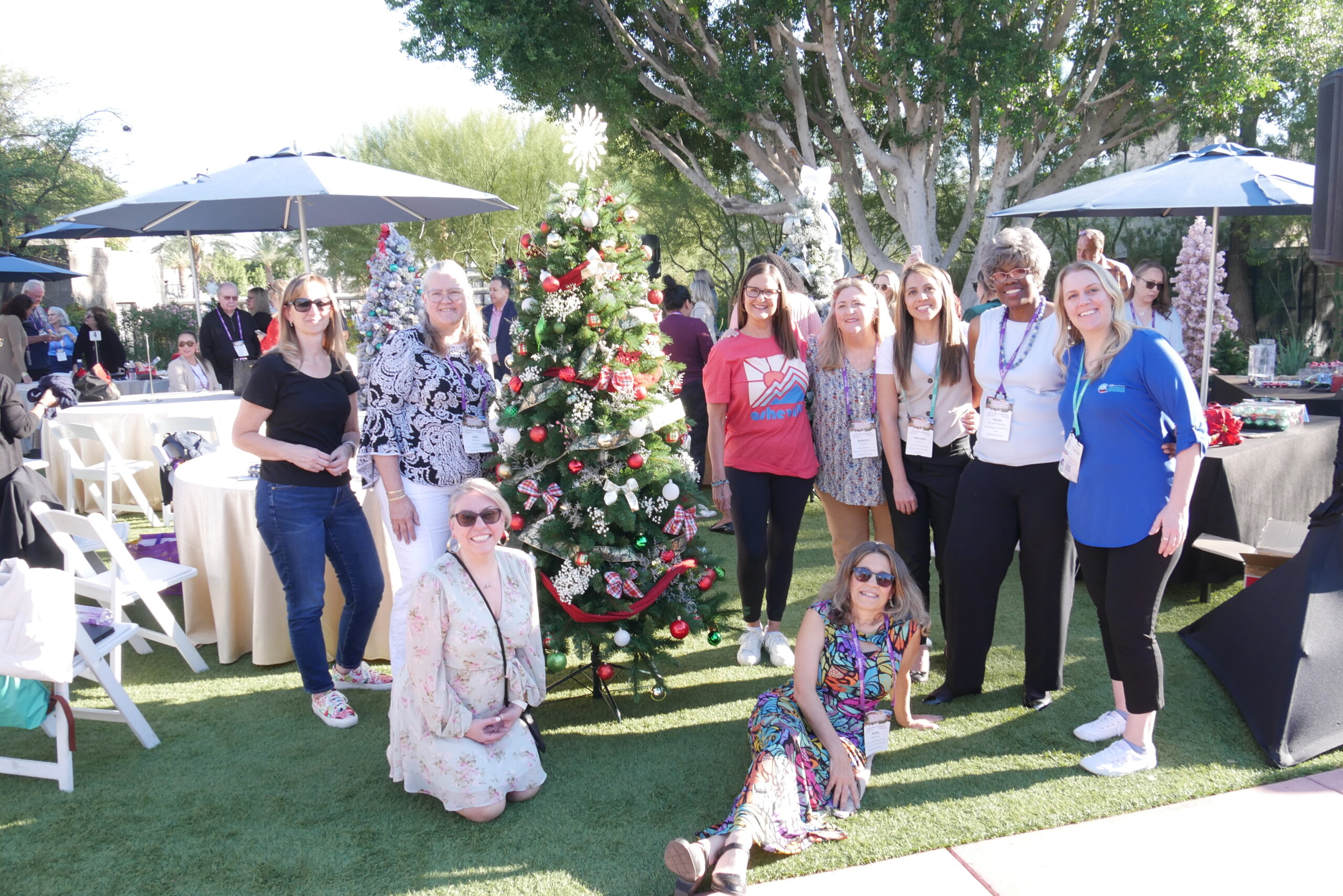 Group of people standing next to decorated Christmas tree