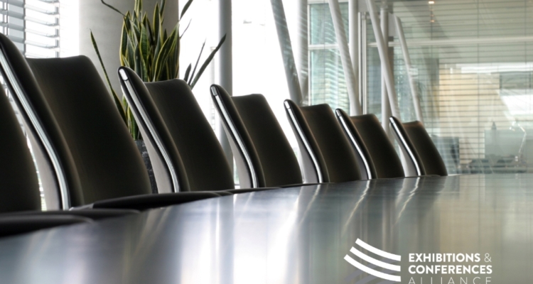 Image of empty boardroom table and chairs with windows and plant in background. January 15, 2025